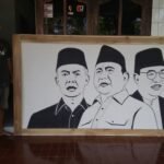 Foto : Ja'far Labib bersama hasil karyanya, lukisan tiga wajah Calon Presiden (Capres) 2024 (Sumber : Dok. Pribadi)